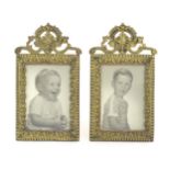 A pair of late 19th / early 20thC cast brass frames with foliate and beaded detail surmounted by