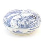 A Chinese blue and white ink box and cover of circular form decorated with figures in landscapes,