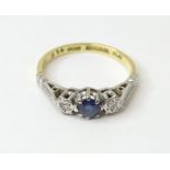 An 18ct gold ring set with central sapphire flanked by diamonds in a platinum setting. Ring size