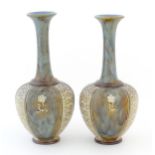 Two Royal Doulton bottle vases with flared rims and floral decoration. Marked under, with maker's