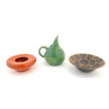 Three studio pottery items to include a green glazed jug with a bulbous body; a wide rimmed bowl