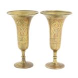 A pair of brass pedestal vases of fluted form with stylised foliate detail and red detail. Approx. 8