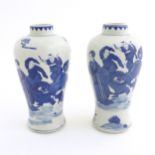 A pair of Chinese blue and white vases decorated with a Chinese dragon parade with figures in a