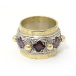 A silver dress ring with gilt detail, set with amethysts and garnet, hallmarked London 1989, maker
