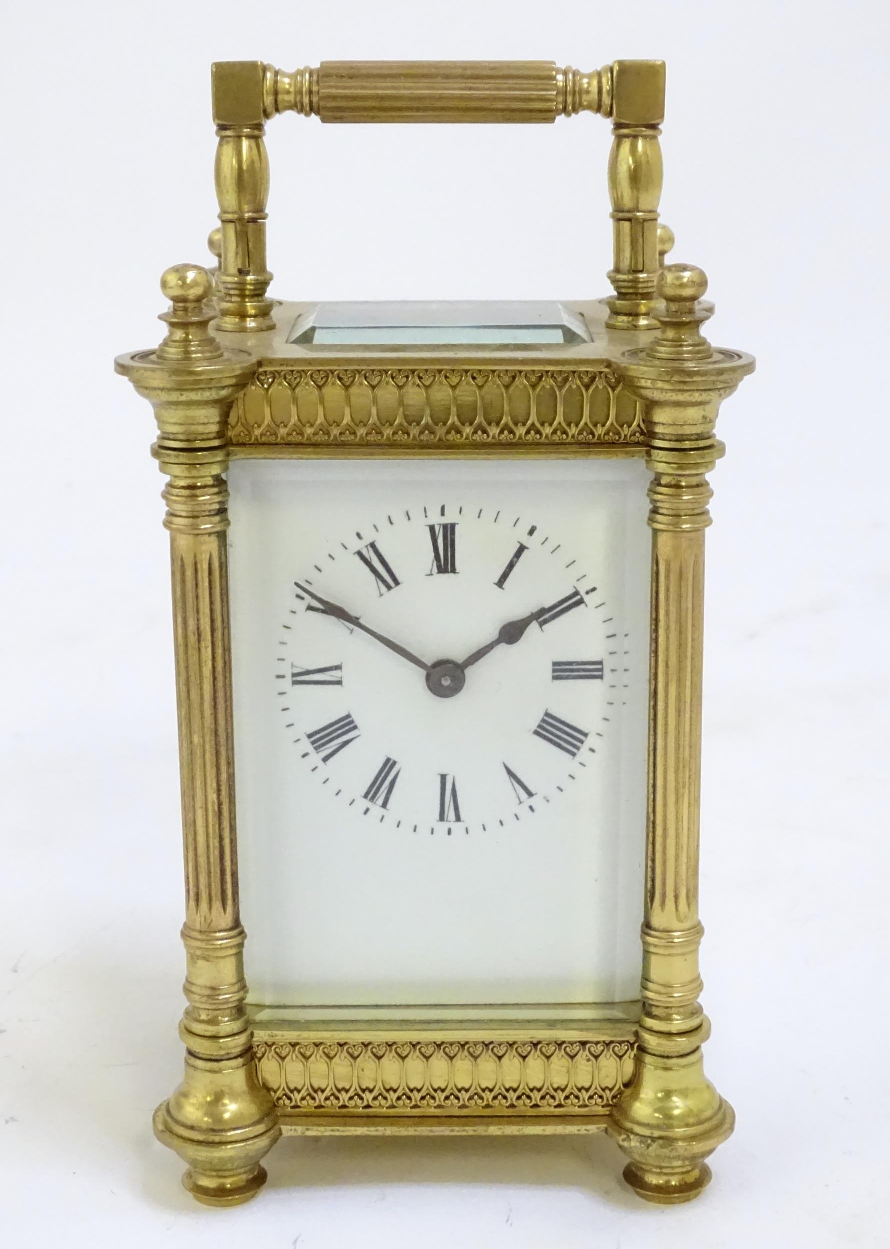 A brass carriage clock with white enamel dial. the whole 6 1/2" high overall. Please Note - we do