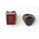 Two white metal gentleman's rings set with hardstone seals, one a carnelian, the other a bloodstone.