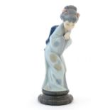 A Lladro model of a Japanese Geisha girl bowing with her hands together, model no. 4989. Marked