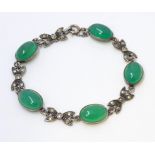 A silver bracelet set with marcasite detail and green jadiete cabochons. Approx 7" long Please