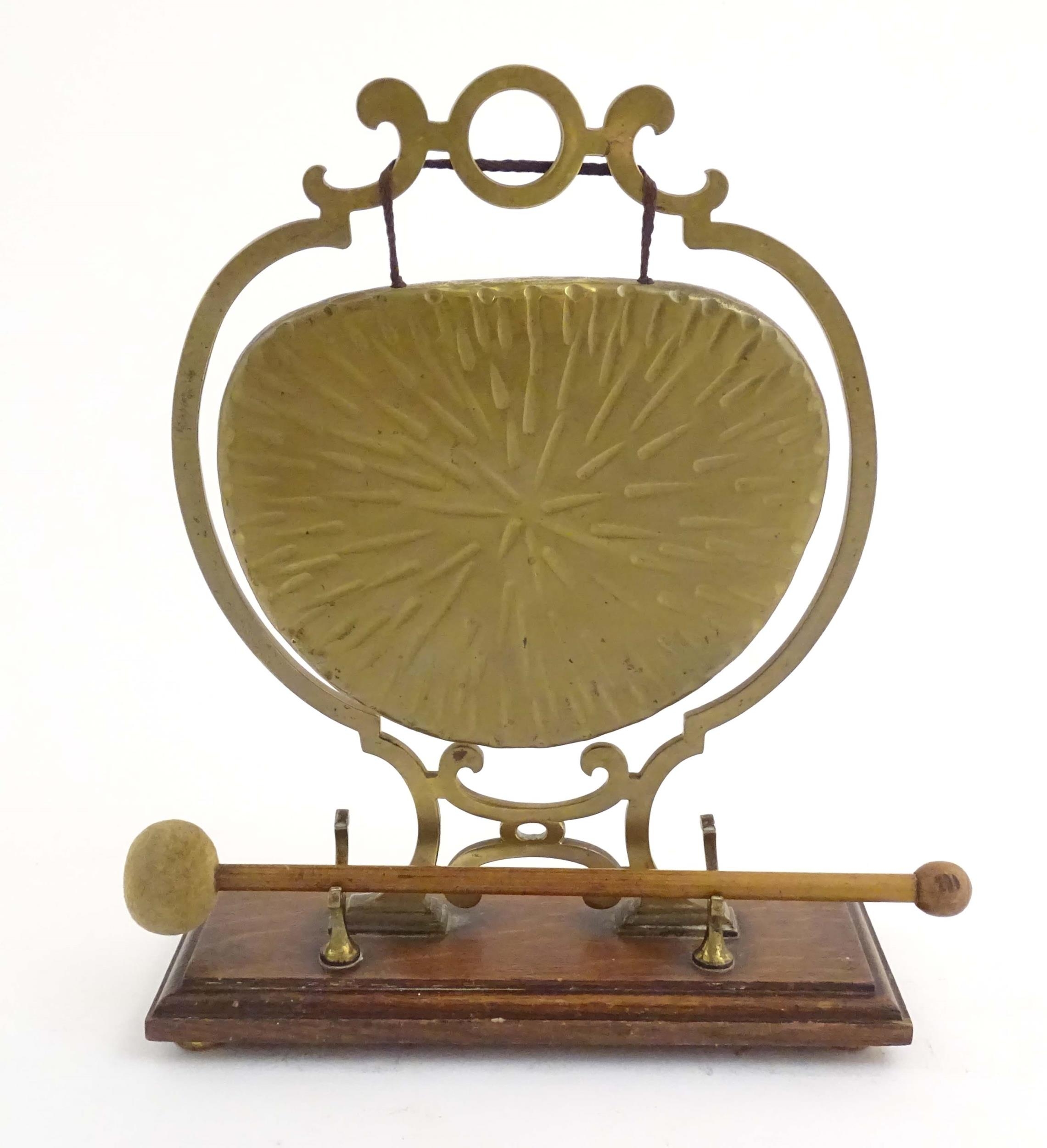 A 20thC brass table gong within a scrolling brass surround, on a rectangular oak base with beater. - Image 3 of 8