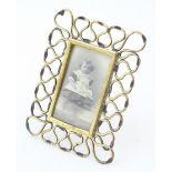 A Victorian easel back photograph frame with brass openwork surround. Approx. 6 1/2" x 5 1/4"