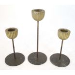 Three mid century modernist candlesticks, the reeded brass sconces on a cylindrical stem on a