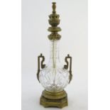 An early-20thC glass table lamp, decorated with prism, star, roundel and vesica cuts, fitted with