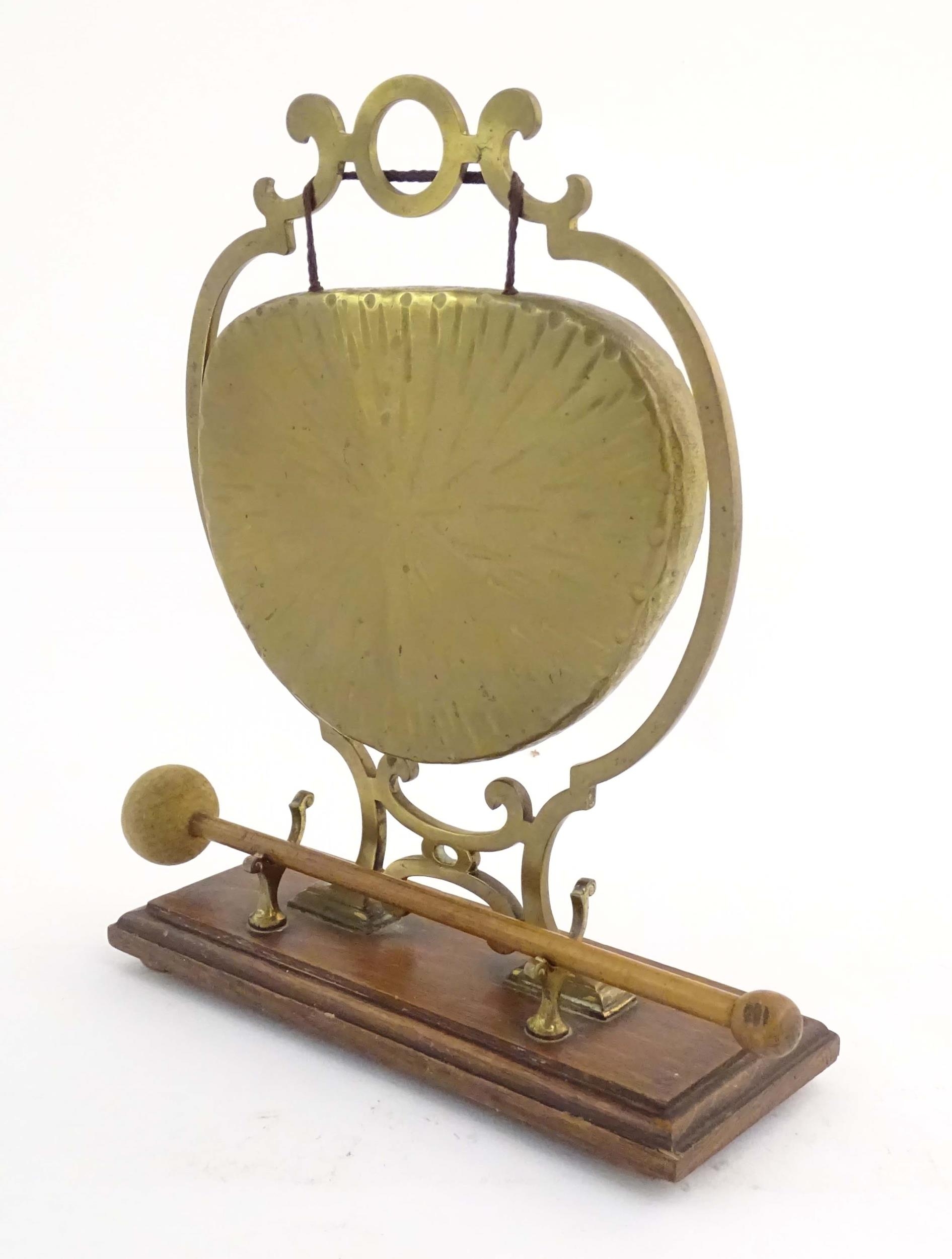 A 20thC brass table gong within a scrolling brass surround, on a rectangular oak base with beater. - Image 4 of 8