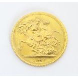 Coin: A Queen Elizabeth II 1966 gold sovereign coin. Approx. 7/8" diameter. Total weight approx.
