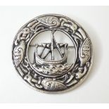 A silver brooch with Iona style decoration depicting longboat to centre bordered by bird and
