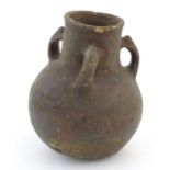 A pottery three handled vase with a bulbous body in the manner of a bronze age drinking vessel.