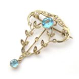 An Art Nouveau yellow metal brooch / pendant set with seed pearls and blue stones Approx 1 1/2" long