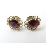 A pair of 9ct gold stud earrings set with garnets. Approx. 1/2" Please Note - we do not make