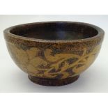 A treen bowl of turned wooden form with a short footed base, with pokerwork decoration and an