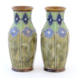 A pair of Royal Doulton vases decorated with stylised floral detail and tube lining. Marked under,