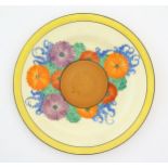 A Clarice Cliff plate decorated in the Gayday pattern with flowers, foliage and a banded border.