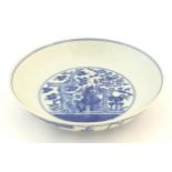 A Chinese blue and white plate decorated with trees and flowers, the reverse decorated with
