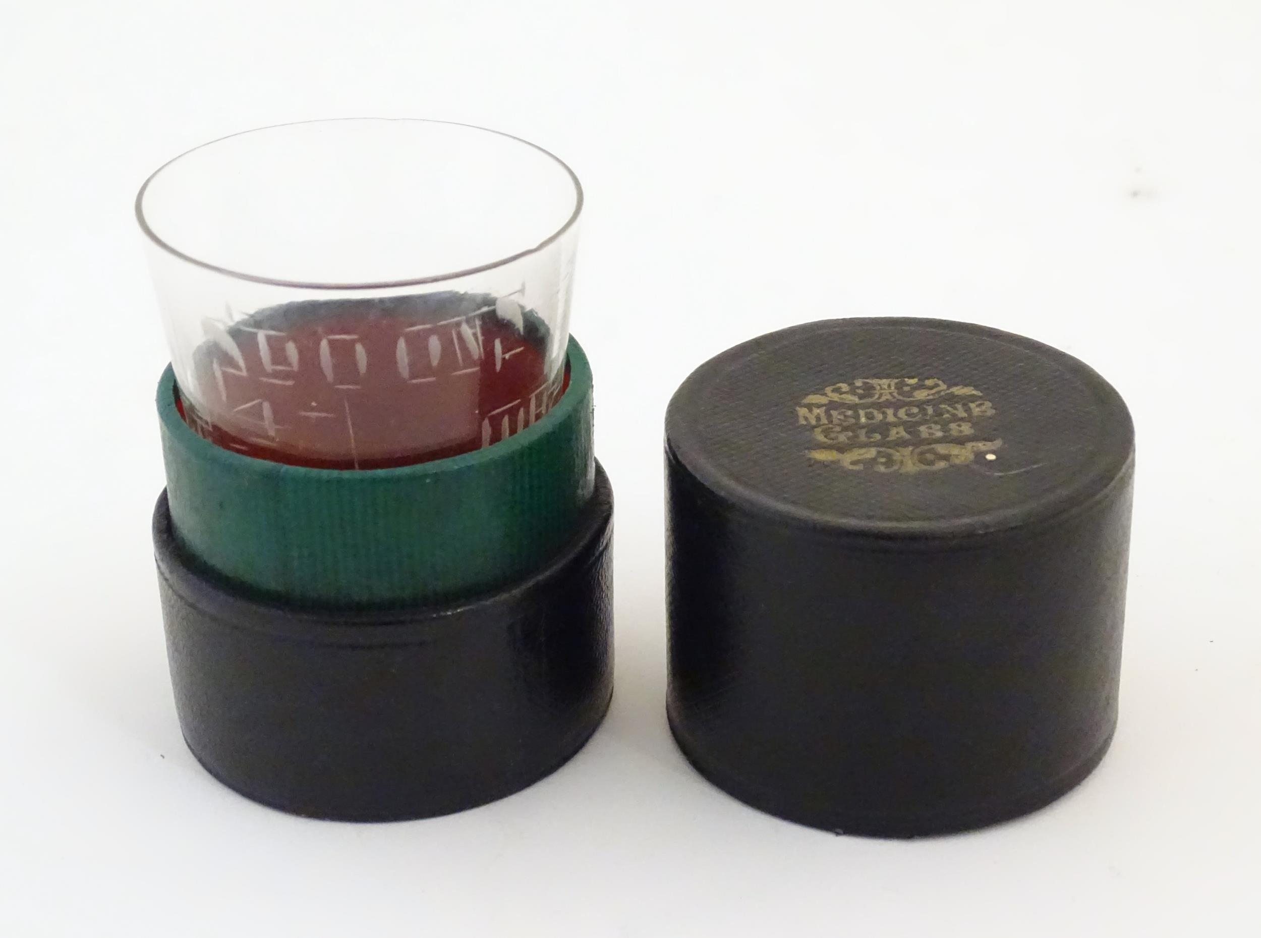 A 19thC medicine measuring glass, in a fitted cylindrical leather case Please Note - we do not