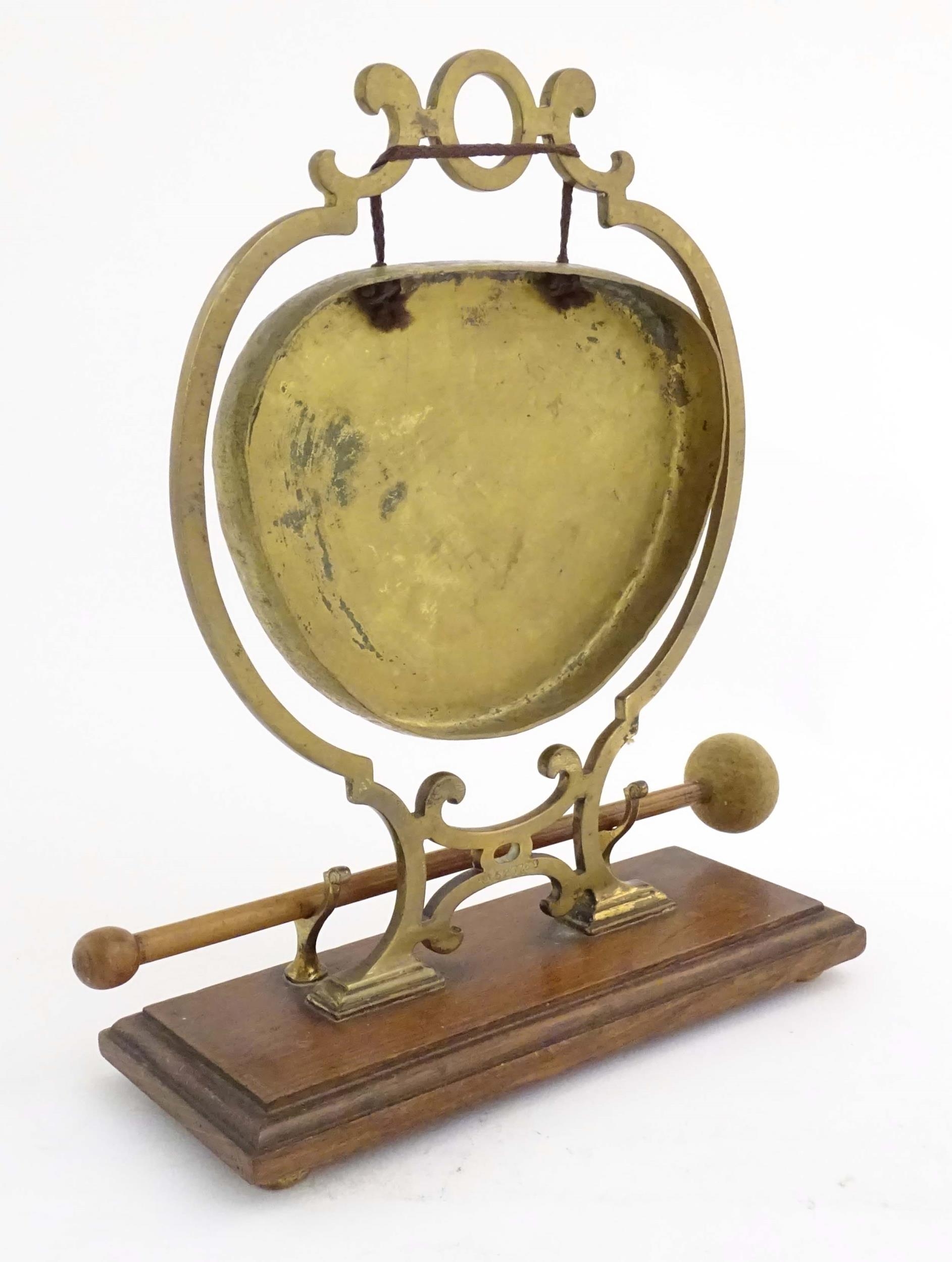 A 20thC brass table gong within a scrolling brass surround, on a rectangular oak base with beater. - Image 5 of 8