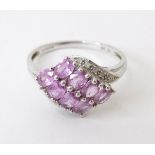 A 9ct white gold ring set with 8 pink sapphires flanked by diamonds. Ring size approx. P Please Note