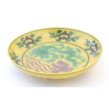 A small Chinese plate with a yellow ground with dragon and phoenix bird decoration. Character