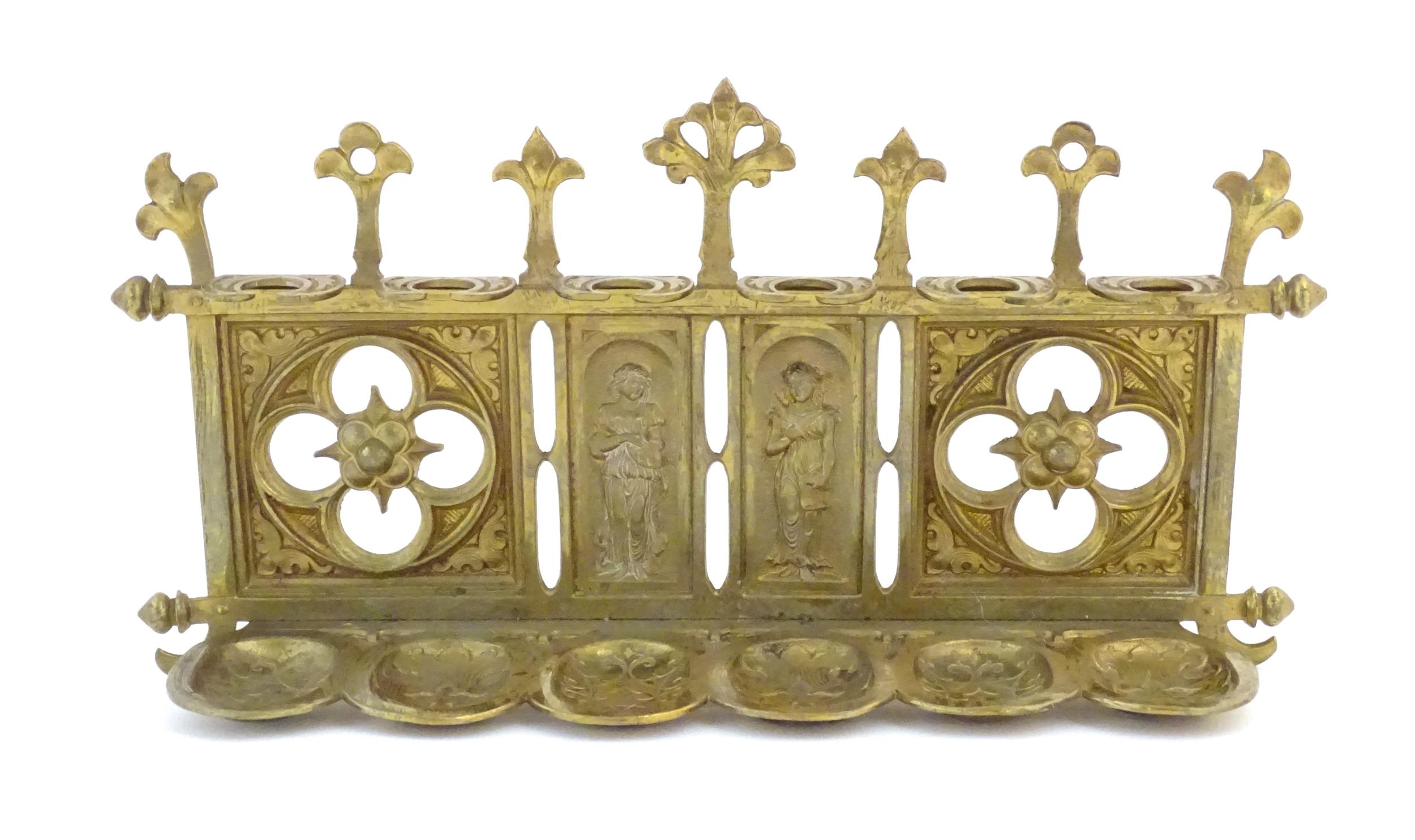 An early 20thC cast brass pipe rack with provision for 6 pipes with Gothic style decoration, pierced