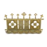 An early 20thC cast brass pipe rack with provision for 6 pipes with Gothic style decoration, pierced