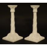 A pair of Royal Worcester candlesticks with relief twist decoration to columns and swag detail to