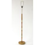 A mid 20thC Scandinavian standard lamp, the column with alternating sections of carved teak and