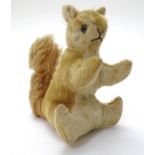 Toy: A 20thC stuffed Steiff style mohair seated squirrel toy with a stitched nose and mouth and