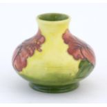 A small Moorcroft squat vase with a yellow ground decorated in the hibiscus pattern. Marked under.