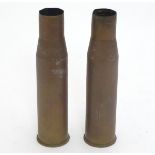 Militaria: a pair of 20thC 40mm Bofors cannon shell cases, headstamped 'M23 A2.' Each 8 3/4'' long