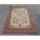 Carpet / Rug: A rug with a terracotta ground with floral and geometric motifs. Approx 112" x 79"