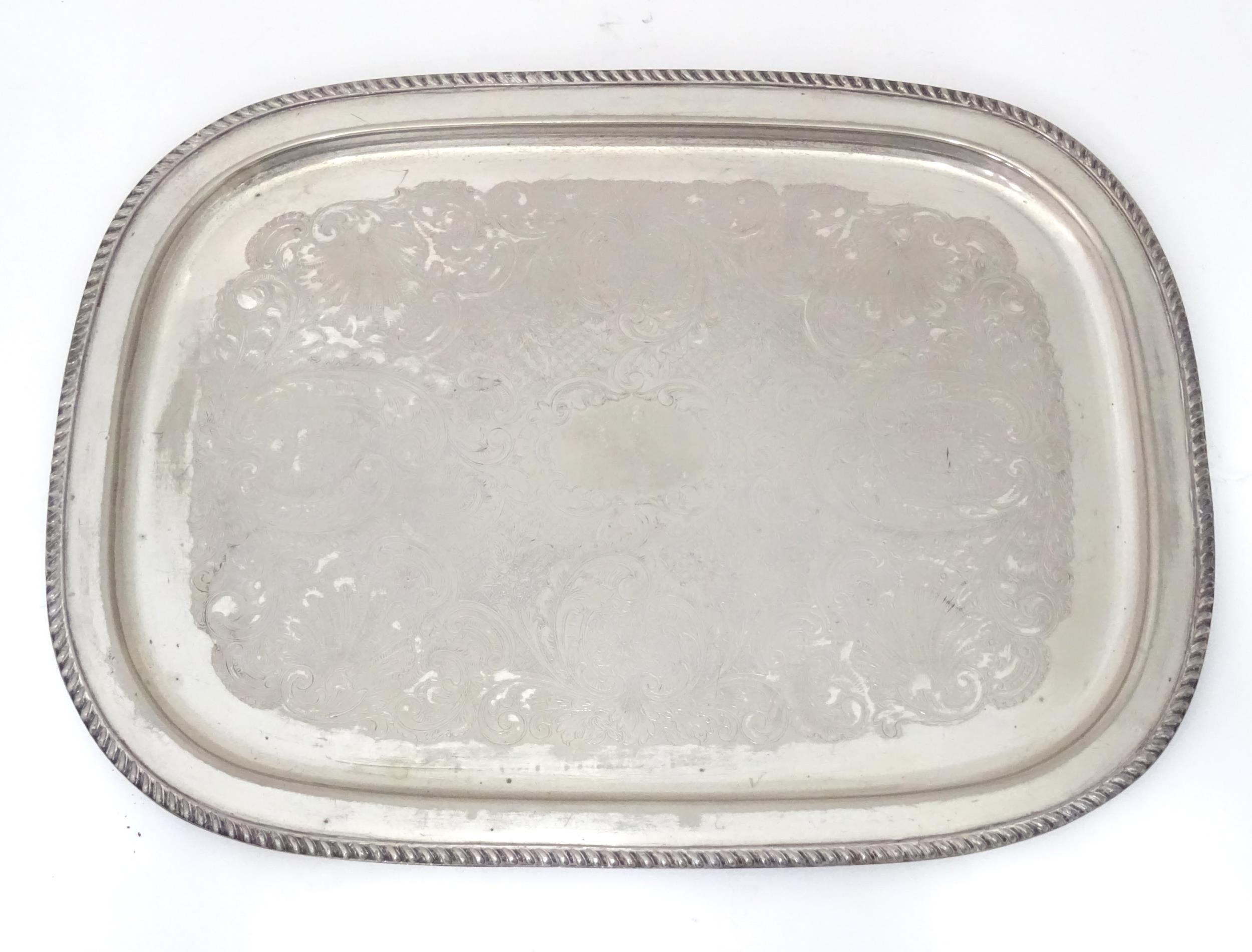 A large silver plate tray with engraved decoration. Approx. 22 1/2" wide Please Note - we do not