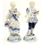 Two KPM style blue and white figures, one modelled as a lady with a basket of flowers, the other