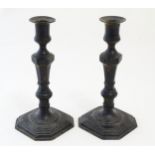 A pair of 20thC cast candlesticks with double knop faceted stems on a stepped square base with