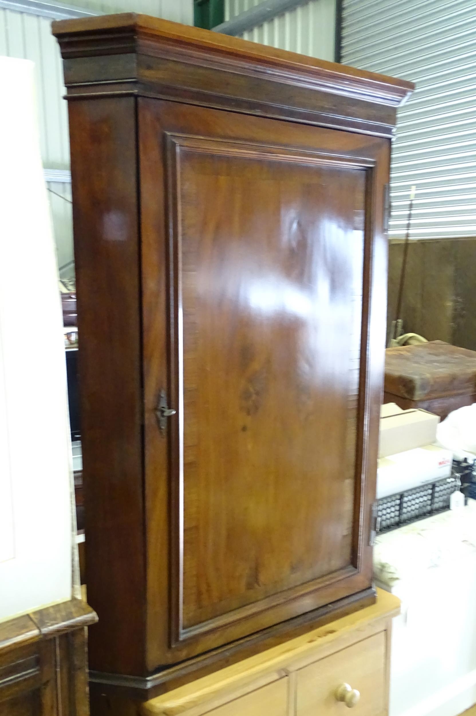 A 20thC mahogany corner cupboard. Approx. 39" high x 26 1/2" wide Please Note - we do not make