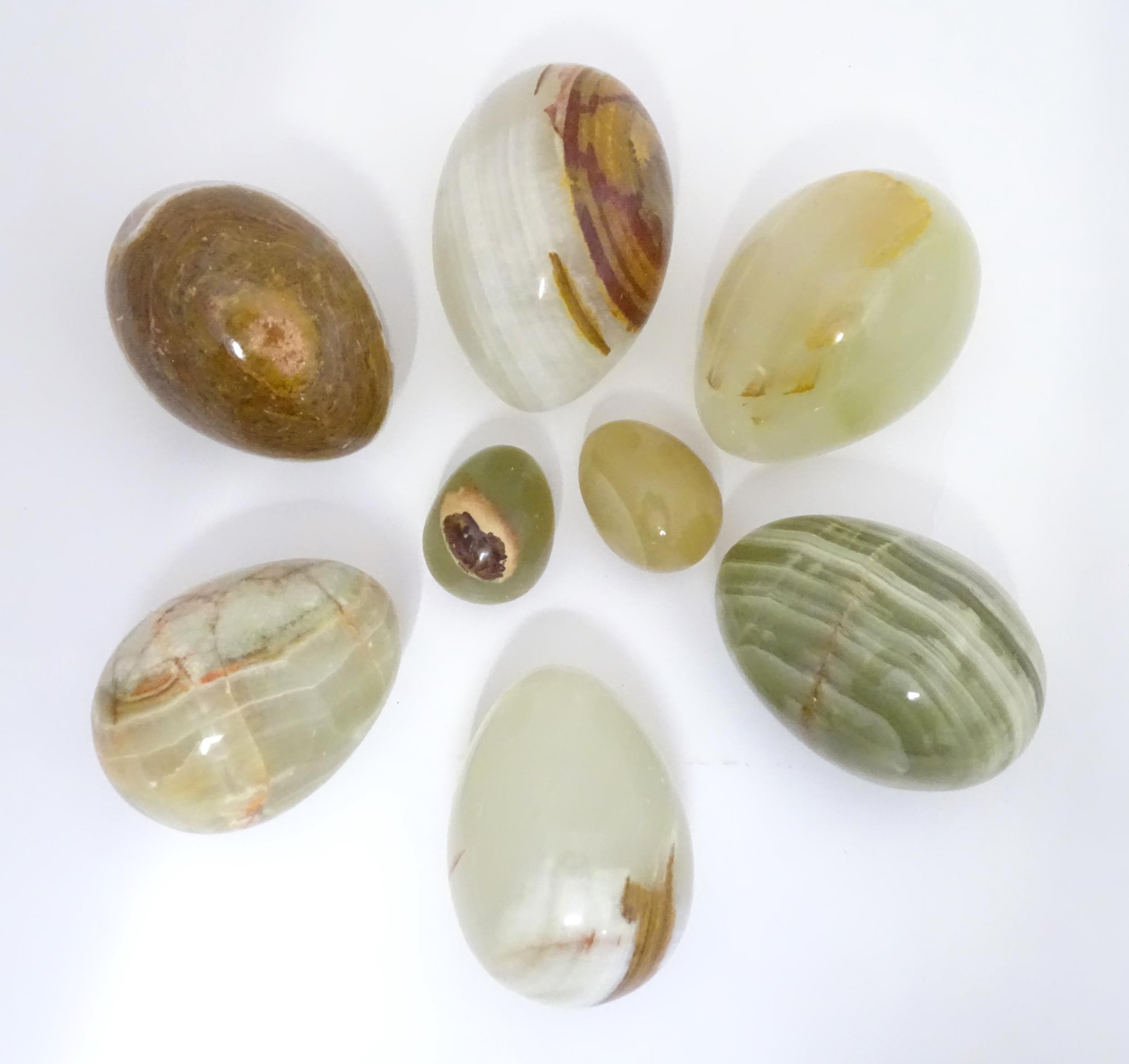 A quantity of 8 onyx/glass eggs largest approx. 3" long Please Note - we do not make reference to