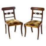 A pair of early / mid 19thC mahogany side chairs, having rounded top rails with decoratively