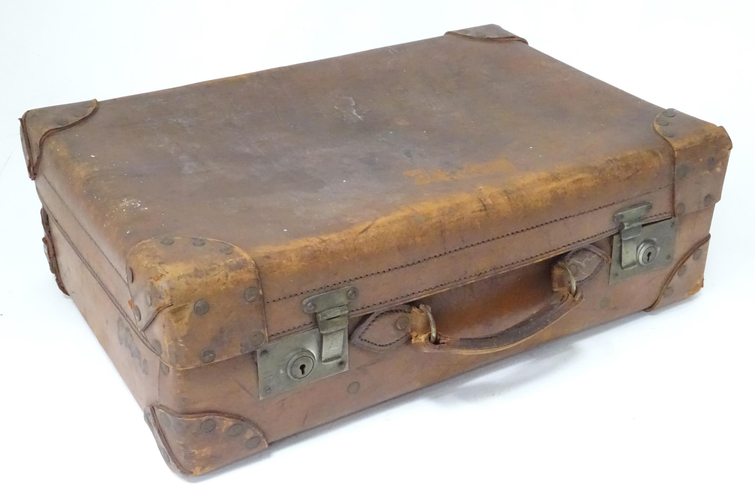 A leather suitcase with reinforced corners and brass locks Please Note - we do not make reference to