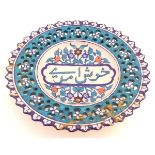 A 19thC Persian dish with Islamic script to the centre surrounded by stylised flowers and foliage,