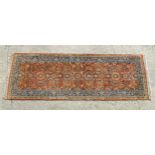 Carpet / Rug : A runner, the salmon ground with floral and foliate detail and decorative blue and