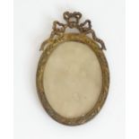 A Victorian gilt metal oval frame / portrait miniature frame with ribbon cresting to top. Approx. 4"
