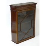 An early 20thC mahogany wall hanging cabinet with satinwood cross banding, astragal glazed door