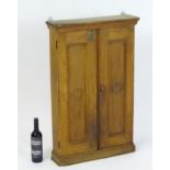 An early 20thC cigar / spice cabinet with a moulded cornice above two panelled doors. 23” wide x